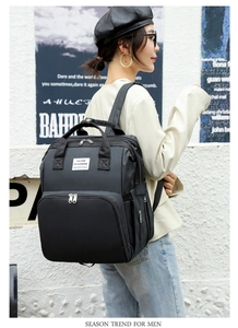Fashionable black foldable mommy backpack with 'You Are My Sunshine' patch on street model
