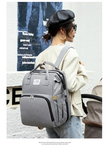 Stylish grey Oxford fabric diaper backpack with large capacity worn by a fashion model