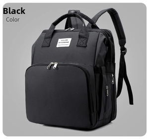 Close-up of black multifunctional diaper bag with sunshine text label and silver zippers