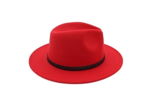 Detail of red wool fedora hat featuring a stylish black decorative band and brim texture