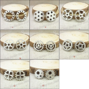 Detail view of retro silver steampunk gear charms for DIY jewelry on wood slices