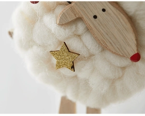 Close-up of Nordic style wool felt sheep ornament with natural wood and golden star