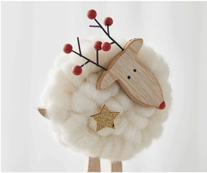 Macro view of wool felt sheep decoration with wooden head and antlers for Christmas