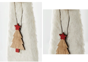 Close-up of wooden Christmas tree pendant with red star on soft white plush background