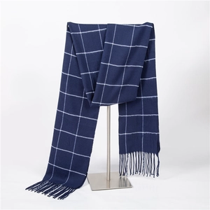 Detail of dark blue and white plaid scarf with fringe trim in soft cashmere-like fabric