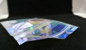 Close-up van holografische laserzak met iriserende regenboogfolie-effecten op zwart