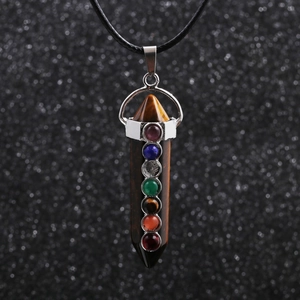 Detailed close-up of a tiger eye hexagonal pendant with seven colorful small gemstones
