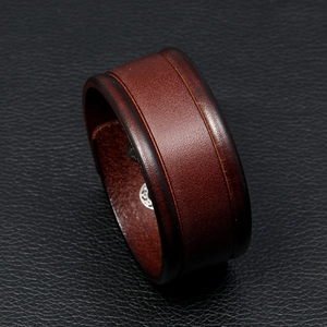 Close-up of brown vintage leather bracelet showing detailed texture on dark leather base