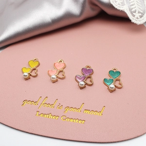 Golden heart-shaped enamel charms with small pearl accents in four pastel colors