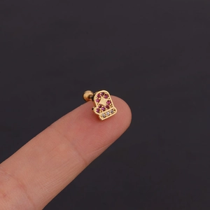 Boucles d'oreilles gants dorés avec zircons rouges et clairs posées sur le doigt