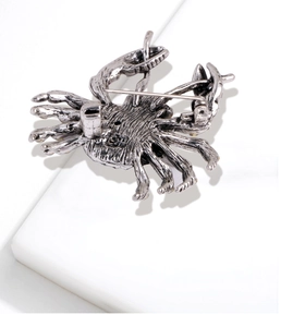 Detailed back view of a silver crab brooch showing the secure safety pin fastener