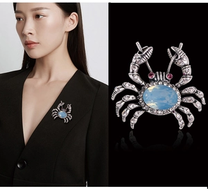 Macro detail of crab brooch with silver finish, sparkling crystals and opal-like gem