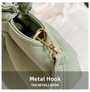 Detailed macro view of high-quality gold hardware hook on light green PU leather handbag
