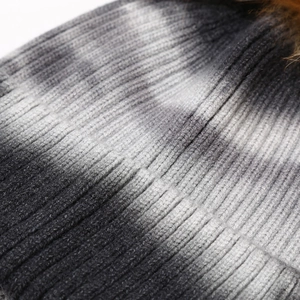 Macro shot of striped tie-dye knit texture on winter hat featuring core-spun yarn detail