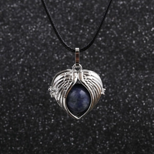 Silver angel wings necklace with a blue gemstone bead on black wax cord with bokeh
