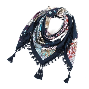 Detail of dark blue bohemian scarf showing floral patterns and navy knotted tassels