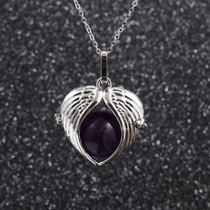 Macro view of silver angel wings heart pendant with purple amethyst bead and chain