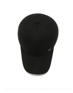 Top view of a thick black wool baseball cap with a metal logo and woven texture
