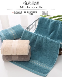 Close-up of cotton towel set with thick looped texture and elegant gold striped borders