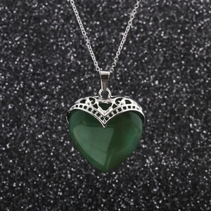 Collier en acier inoxydable avec pendentif cœur en jade vert sur fond noir scintillant