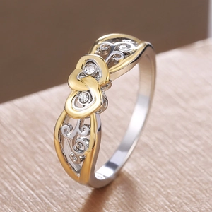 Minimalist silver and gold heart ring featuring cubic zirconia stones and filigree