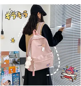 Detailed view of pink school backpack with cute bear pendant and decorative charms