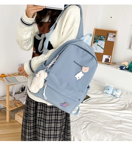Close-up of blue nylon backpack featuring Duociyuan lettering and cute bear accessories