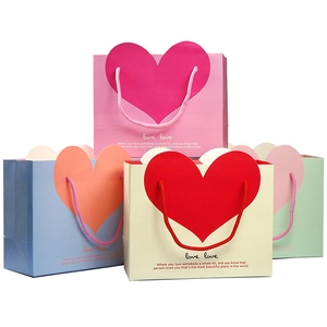 Close-up of pastel paper gift bags with large heart patterns and matching handles