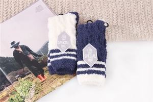 Close-up of soft coral fleece striped sleep socks with special gift tag on a magazine