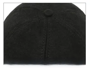 Macro shot of 6-panel crown stitching and top button on a black winter cotton cap