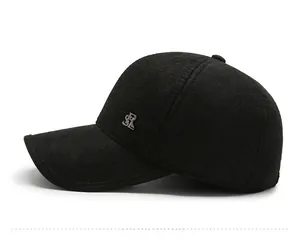 Detail of black winter baseball cap showing fine twill fabric and silver metal logo
