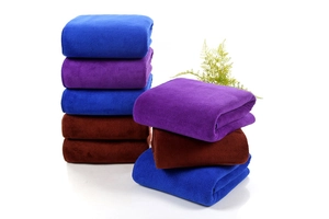 Close-up of thick microfiber car wash towels in blue, purple, and brown colors
