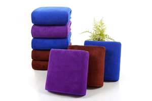 Detailed texture of thick microfiber towels in blue, purple and brown on white surface