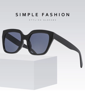Close-up of stylish black large square frame sunglasses on a geometric white stand