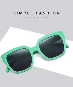 Detail of mint green square cat-eye sunglasses with thick temples on minimalist background