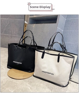 Detail of black and beige large tote bags with JINGPINPIJU lettering on marble background