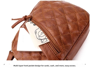 Detail of brown quilted crossbody bag featuring front zipper pocket and ample storage