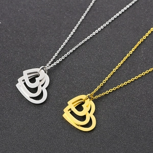 Dual-layer hollow heart pendant necklaces in silver and gold tones on black background