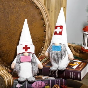 Gnomes de Noël infirmière et médecin avec masques et croix rouge sur des livres