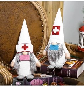 Détail de gnomes de Noël médecin et infirmière avec croix médicale sur des livres