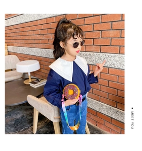 Détail du sac bandoulière enfant en forme de donut marron avec sangle arc-en-ciel