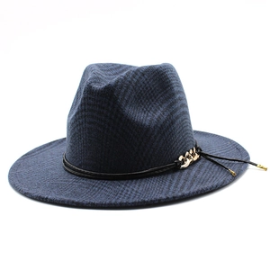 Detail of dark blue fedora hat featuring golden chain accents and leather strap