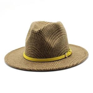 Detail of the brown plaid texture and yellow leather belt buckle on a vintage fedora hat