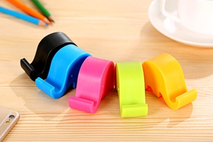 Close-up of elephant phone stands in vibrant colors on a wooden table setup