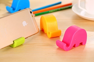 Colorful elephant silicone phone holder set on desk with soft background lighting