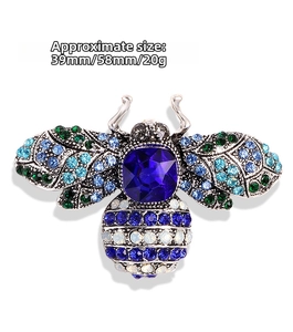 Detail view of crystal bee brooch showing blue gemstone and 58mm by 39mm dimensions