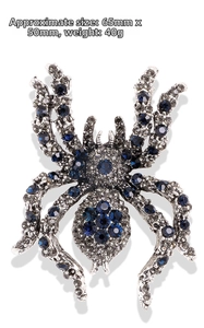 Macro detail of a crystal-encrusted spider brooch with blue rhinestones and measurements
