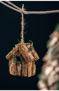 Detailansicht eines handgefertigten Vogelhaus-Anhängers aus Baumrinde mit Moos-Deko
