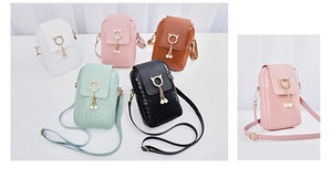 Detail showing woven texture crossbody phone bag with gold cat ears and pearl charms
