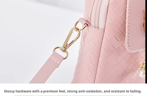 Detail of pink woven texture phone bag featuring gold hardware and pearl pendant